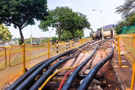 Electrical new high voltage cables on large wood drums been installed in underground Trenches industrial construction project.