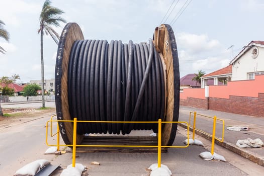 Electrical new high voltage cables on large wood drums been installed in underground Trenches industrial construction project.