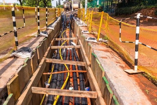 Electrical new high voltage cables been installed in underground trenches industrial project closeup photo.