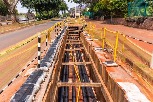 Electrical new high voltage cables been installed in underground trenches industrial project closeup photo.