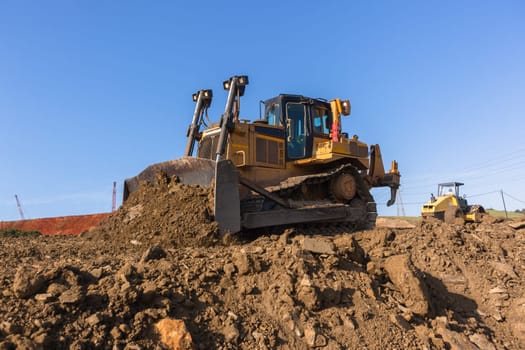 Construction industrial earthworks site  landfill grader dozer machine  leveling sand stones landscape