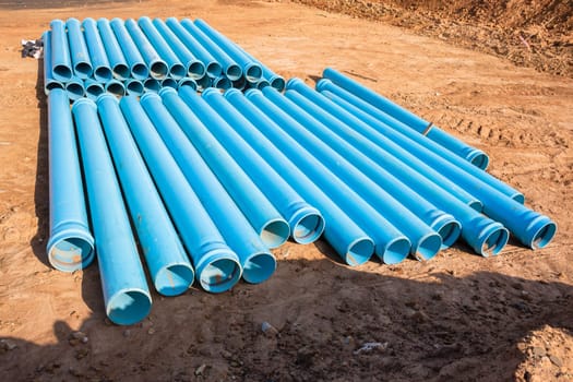 Construction blue plastic nylon pipes  stack on building site for plumbing infrastructure earthworks