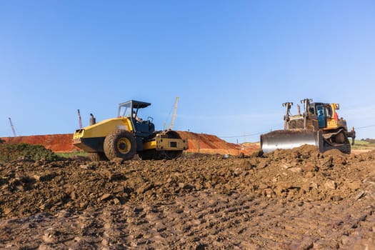 Construction industrial earthworks landfill dozer machine scoop bucket moving sand stones closeup abstract.
