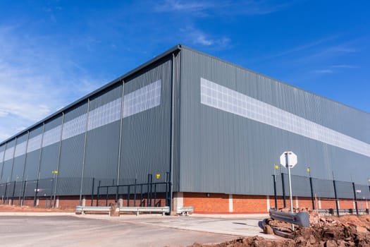 New large warehouse  factory industrial building structure in blue morning sky.