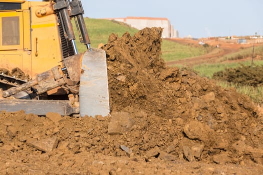 Construction industrial earthworks landfill dozer machine scoop bucket moving sand stones closeup abstract.