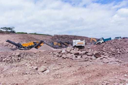 Construction mobile industrial quarry stone crushing machines producing mix grades for concrete cement on building site.