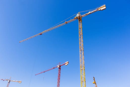 Building construction site industrial cranes concrete levels earthworks halfway apartment housing project.