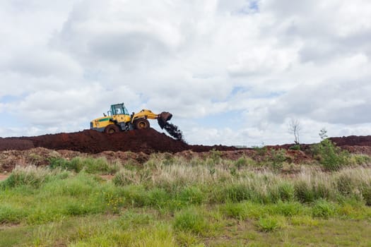 Industrial earthworks industrial vehicle loader bucket machine on building construction site.