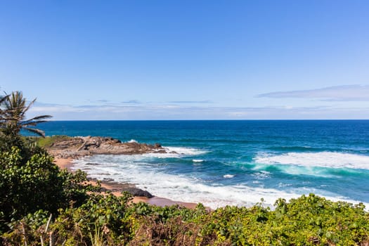 Beach ocean waves rocky coastline horizon summer blue holiday landscape.
