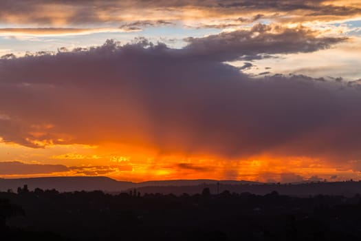 Sunset sundown clouds color contrasts over countryside hills homes a scenic landscape