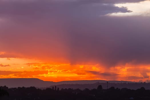 Sunset sundown clouds color contrasts over countryside hills homes a scenic landscape