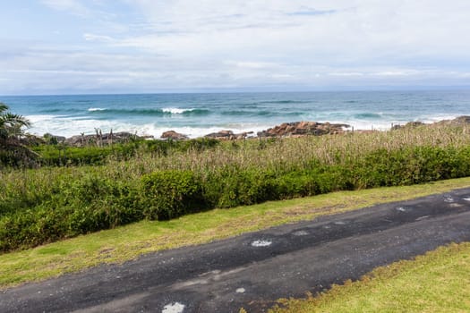 Beach road with ocean waves rocky coastline scenic holiday landscape