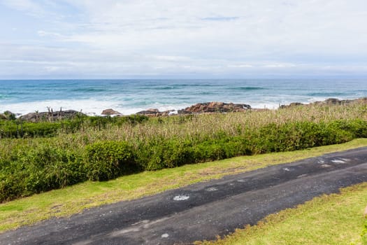 Beach road with ocean waves rocky coastline scenic holiday landscape