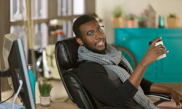 Handsome professional man in a creative office with coffee