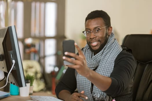 Handsome professional man in a creative office using his mobile device