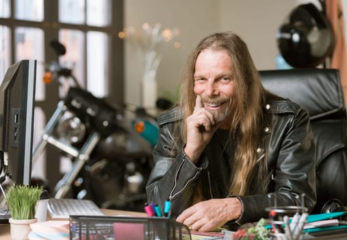 Happy man at his desk with a motorcycle