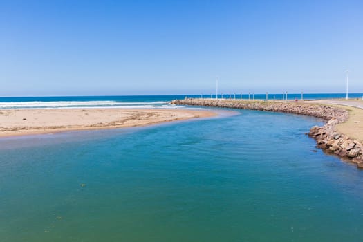 Beach river-mouth ocean waves along rocky coastline scenic summer landscape.