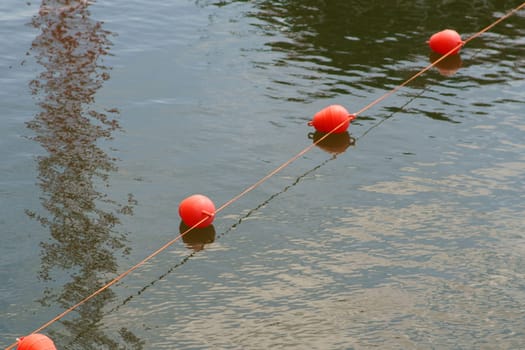 A stretched rope with juxtaposed swimming buoys to block traffic in the inland port...