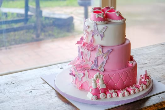 fist cake for a little baby girl birthday for celebrating baptism - pink sugarpaste layered cake design no people .