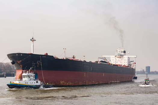 Big Cargo Containers Boat with Goods cargo Stack at the Pier docks port waiting for international sea freight transportation in Rotterdam Port of Netherlands