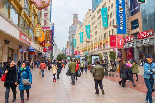 HANGHAI, CHINA - DEC 28, 2016: People walking on Nanjing road in Downtown of Shanghai. The area is the main shopping district of the city and one of the world's busiest shopping streets