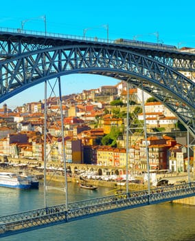 Sunshine cityscape of Porto touristic oldtown by Douro river with Dom Luis I Bridge in foreground, Portugal