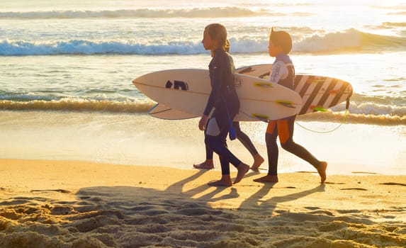PENICHE, PORTUGAL - OCTOBER 20, 2018: Three boys in wetsuits with surfboards at ocean coast, Peniche, Portugal
