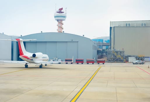 Small airplane near a hangar at airport. Singapore