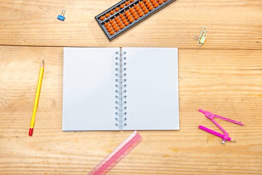 Open notebook with school supplies and stationery on the wooden table. Back to School concept