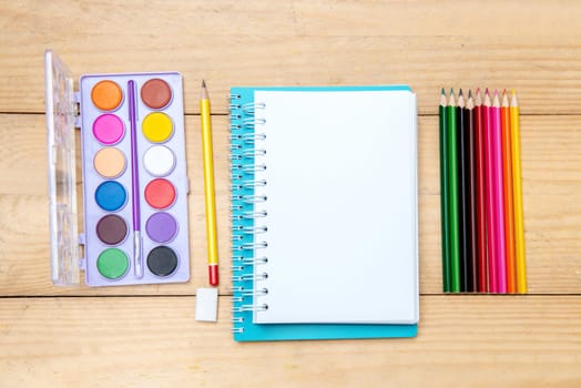 Notebooks with school supplies and stationery on the wooden table. Back to School concept