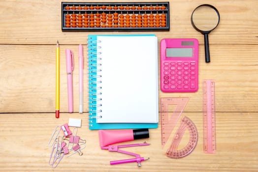 Notebooks with school supplies and stationery on the wooden table. Back to School concept