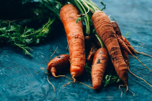 Fresh carrots on a blue wooden background.