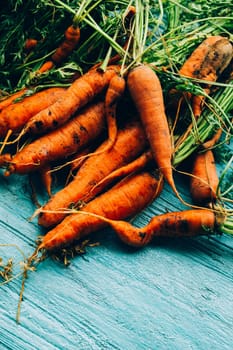 lot of carrots on a wooden background.