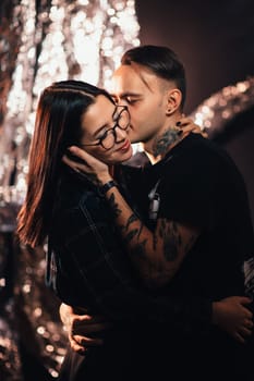 Couple in fashionable clothes on a shiny background.