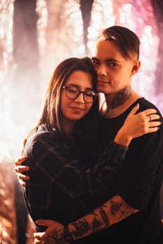Couple in fashionable clothes on a shiny background.