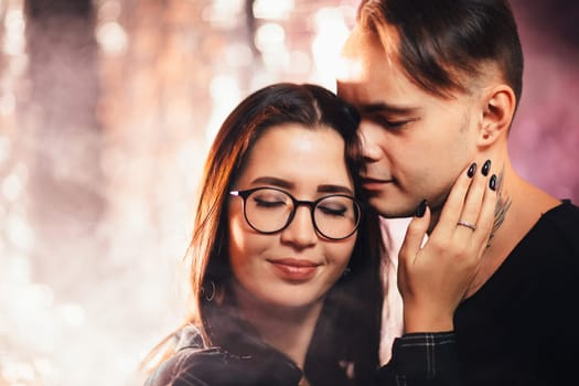 Couple in fashionable clothes on a shiny background.