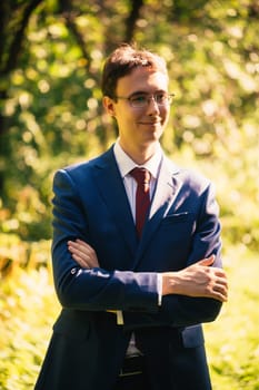 Portrait of the groom in the nature park background.