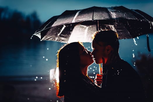 young man and woman under an umbrella and rain.
