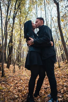 The girl and the guy are walking in the autumn forest.