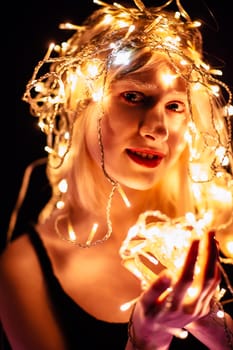 portrait of a girl with a garland on black background.