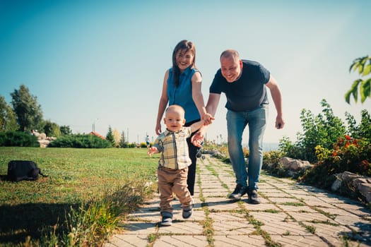 Happy family with baby son on nature background.