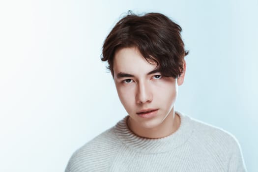 portrait of a teenager brunette guy in a studio.