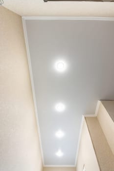 Fragment of a stretch ceiling in a long narrow corridor