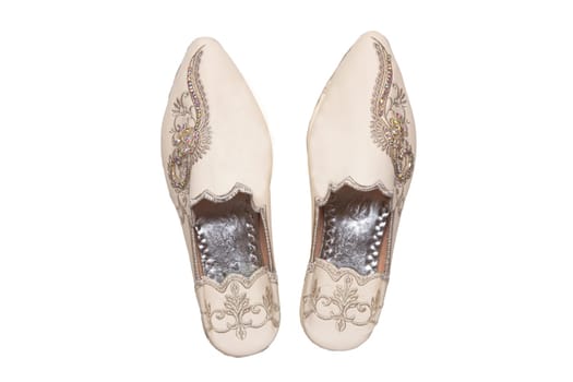 Slippers woman isolated. Closeup of elegant luxurious handmade beige ladies slippers with beautiful floral embroidery and rhinestones. Fashionable shoes.