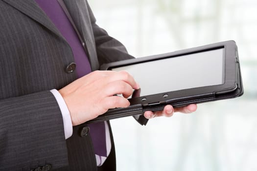 businessman using touch pad, close up shot on tablet pc, at the office