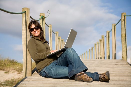 young woman working with computer at the beach