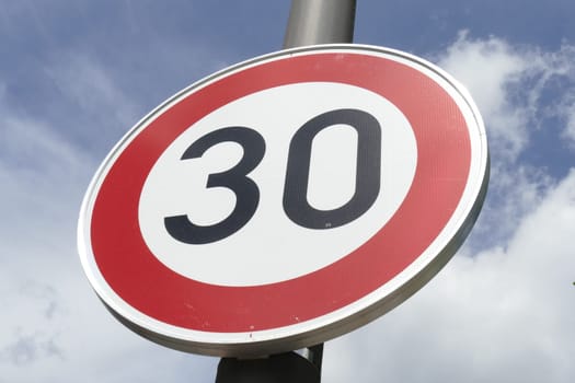 Road sign Maximum Speed ​​30 km / h, Blue sky with clouds