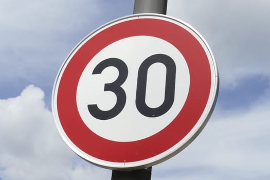 Road sign Maximum Speed ​​30 km / h, Blue sky with clouds