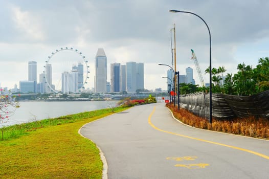 View of Singapore riverbank in Marina Barrage - popular place for workout and sport exercises. Singapore Flyer in the background