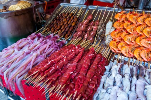 Roasted, fried and raw insects, silkworms, scorpions, bugs, snakes, dog meat, shrimps, octopus on stick as snack street food in China